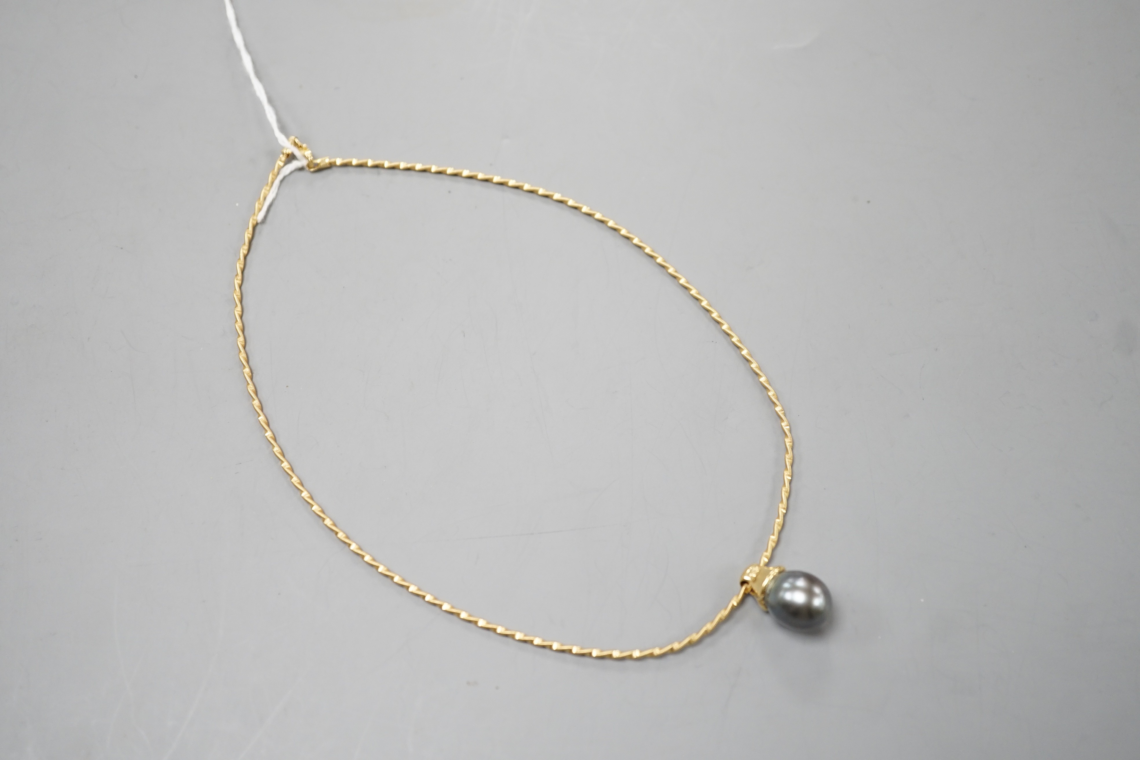 A modern 18k, cultured Tahitian pear and diamond chip set pendant, 19mm, on a 750 yellow metal necklet, approx. 36cm, gross weight 10.3 grams.